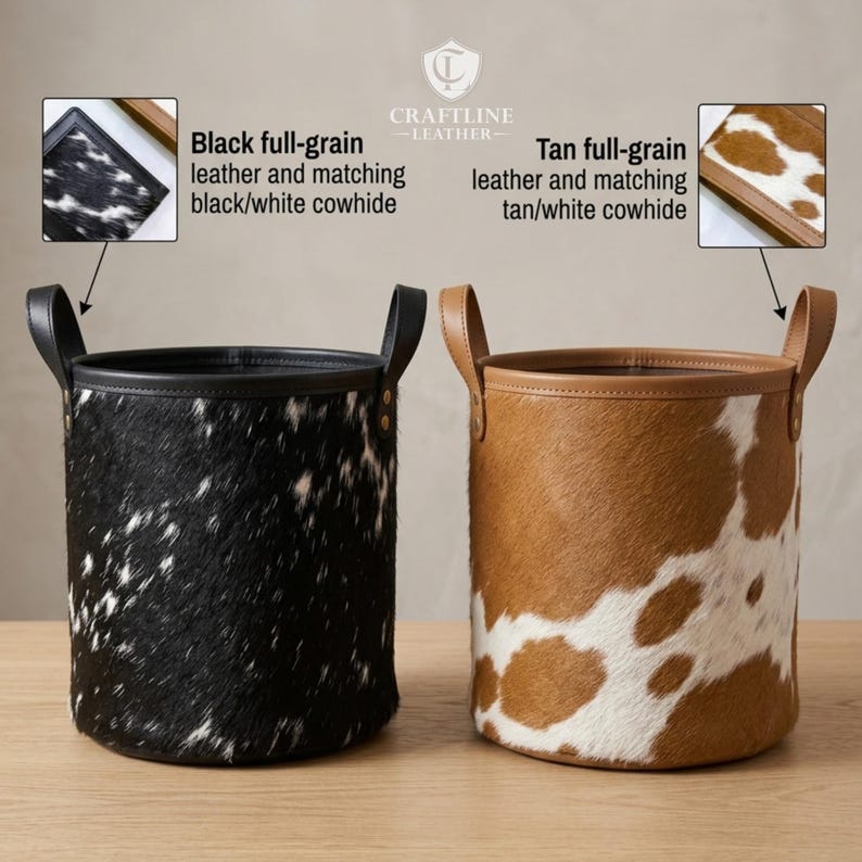 May include: Two cylindrical storage baskets with handles. The left basket features black and white cowhide with black leather trim. The right basket features tan and white cowhide with tan leather trim. Text labels identify the leather and hide types.