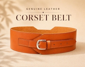 Könnte beinhalten: Breiter, orangebrauner Korsettgürtel aus echtem Leder. Der Gürtel hat eine silberfarbene Schnalle und einen Riemen mit mehreren Verstelllöchern. Der Text "GENUINE LEATHER" und "CORSET BELT" ist im Bild zu sehen.