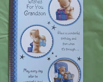 May include: A light blue birthday card for a grandson, featuring illustrations of teddy bears and gifts. The card has text that reads "Birthday Wishes For You Grandson" and other birthday wishes. Decorative stars and a blue patterned border complete the design.