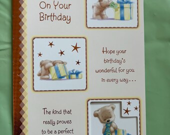 May include: Birthday card with the text "Grandson With Love On Your Birthday". The card features illustrations of teddy bears with gifts and stars. The card's design includes a brown and white patterned border.