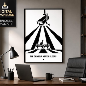May include: A black and white wall art print featuring a surveillance camera mounted above a person sitting on a park bench. The scene is illuminated by a spotlight effect with the text THE CAMERA NEVER SLEEPS printed at the bottom of the frame.