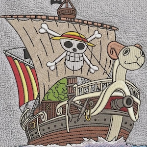 May include: An embroidered patch on a gray textured fabric featuring a brown pirate ship with a ram-shaped figurehead. The main sail displays a skull and crossbones wearing a yellow straw hat. A small black flag with a skull sits at the top.