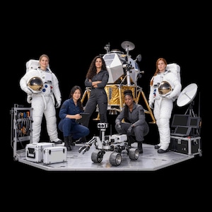 Peut inclure: Quatre personnes se tiennent sur une plateforme métallique avec un atterrisseur lunaire, un rover robotique et des mallettes d'équipement. Deux portent des combinaisons spatiales blanches pressurisées avec casques, deux des combinaisons gris foncé.