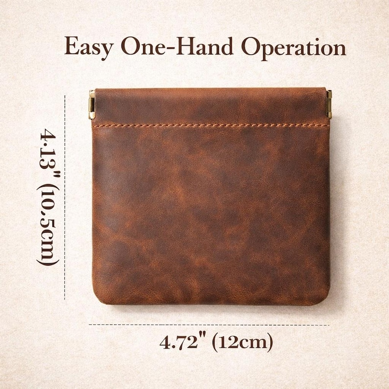 May include: A brown leather coin purse with a rectangular shape. The purse is 4.72 inches (12 cm) wide and 4.13 inches (10.5 cm) tall. The text "Easy One-Hand Operation" is at the top. The purse has a stitched seam and metal accents.
