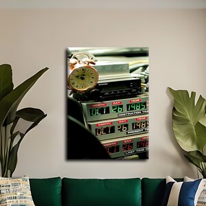 May include: A time circuit display unit featuring three rows of digital green and red LED readouts showing OCT 26 1985, with a metallic analogue alarm clock resting on top of the black electronic housing, capturing a cinematic science fiction aesthetic.