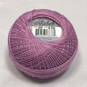 Peut inclure: Une pelote de fil à broder HH Lizbeth de couleur violette, mercerisé et singé. L'étiquette indique "Size 20 Col. 636" et "25g = 210 yds".