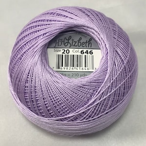 Puede incluir: Una madeja de hilo de bordar de color morado, de tamaño 20, con la etiqueta "HH Lizbeth" y el número de color 646. La etiqueta también incluye un código de barras y la información "5g = 210 yds".