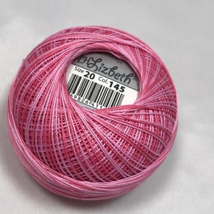 Op de afbeelding: Een roze en witte bol borduurgaren met een label met de tekst "Lizbeth" Maat 20 Col. 145.