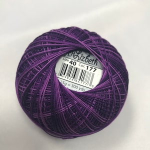 Op de afbeelding: Een bol paarse borduurgaren met een wit label waarop "Size 40 Col. 177" en "25g = 300 yds" staat.