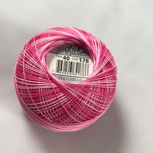 May include: A ball of pink and white yarn with a label that reads "HH Lizbeth Size 40 Col. 176" and "25g = 300 yds".