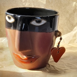 Pot de fleurs vintage en céramique postmoderne, en forme de visage, orné d'une boucle d'oreille en forme de cœur pendante ; cache-pot fantaisiste représentant un visage de femme ; Kadri Kaerma, Estonie