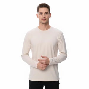 Puede incluir: Una camiseta de manga larga color crema. La camiseta tiene cuello redondo y está hecha de una tela suave y lisa. Las mangas son largas y ajustadas. La persona lleva pantalones negros.