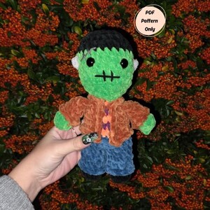 May include: A handmade green Frankenstein's monster plushie with black hair, white ears, and a stitched mouth. It wears a brown jacket, an orange shirt, and blue pants. The image includes the text "PDF Pattern Only".