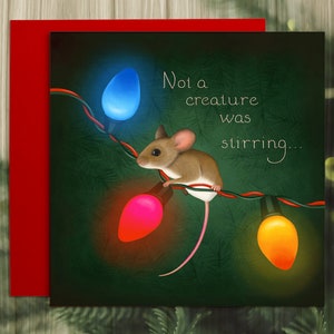 The card illustration shows a tiny house mouse clinging to the wire of an old-fashioned set of string lights. The lights are lit orange, red, and blue. The background is dark green foliage. Text says," Not a creature was stirring"