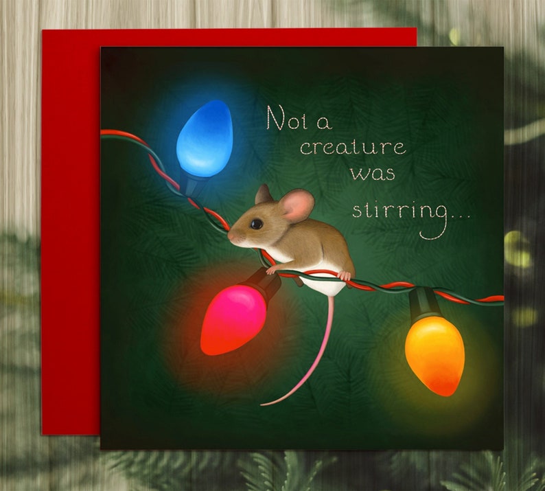 The card illustration shows a tiny house mouse clinging to the wire of an old-fashioned set of string lights. The lights are lit orange, red, and blue. The background is dark green foliage. Text says," Not a creature was stirring"