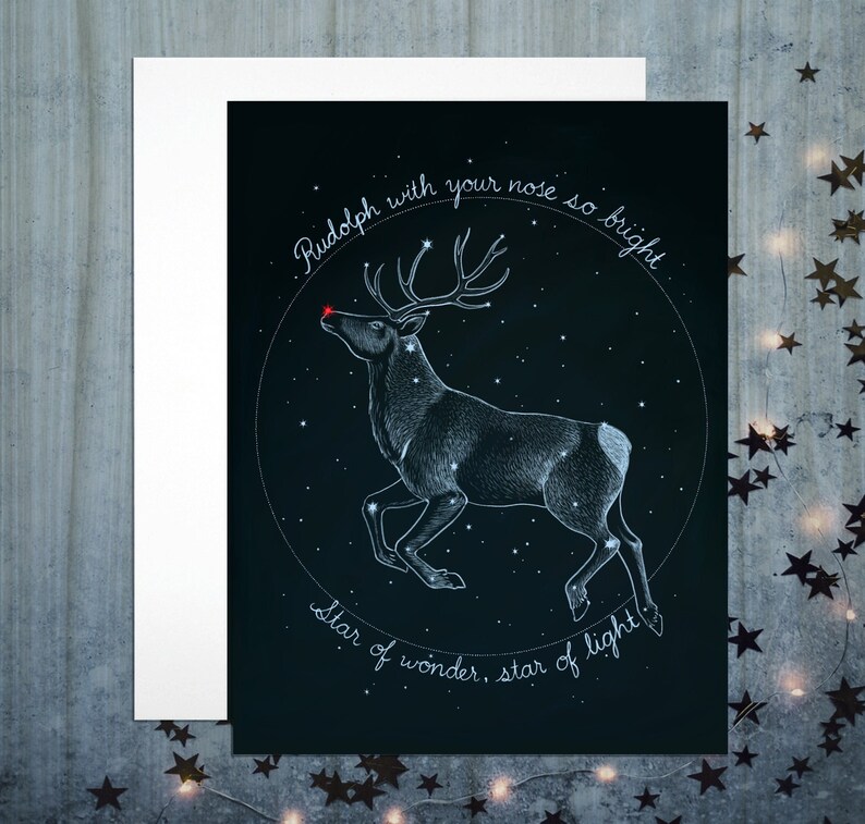 Background is dark night sky. There are stars in the sky. A reindeer constellation is traced out in light blue, with a bright red star at the nose tip. A circle of text says "Rudolph with your nose so bright, Star of wonder, star of light."
