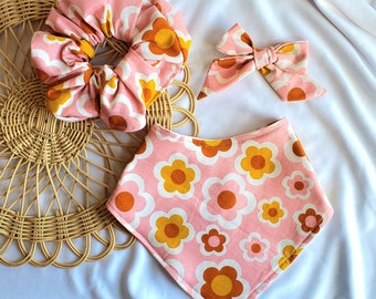 Może przedstawiać: Różowo-żółty bandana-śliniak z kwiatowym wzorem, pasująca kokardka do włosów i różowo-żółty scrunchie z kwiatowym wzorem.