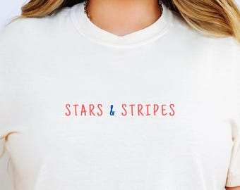 Camiseta minimalista com estampa de estrelas e listras, camiseta cropped creme de verão, roupa patriótica vermelha, branca e azul, look estiloso para o Dia da Independência.