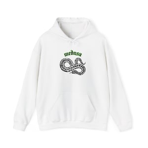 Könnte beinhalten: Weißer Kapuzenpullover mit Fronttasche und Kordelzug. Das Design zeigt das Wort "medusa" in Grün über einer schwarz-weißen Schlangenillustration.