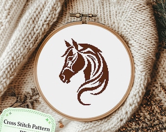 May include: A cross stitch pattern featuring a dark brown horse head silhouette on a white fabric background, held within a circular wooden embroidery hoop. The design displays the horse in profile with a flowing mane and detailed facial features.