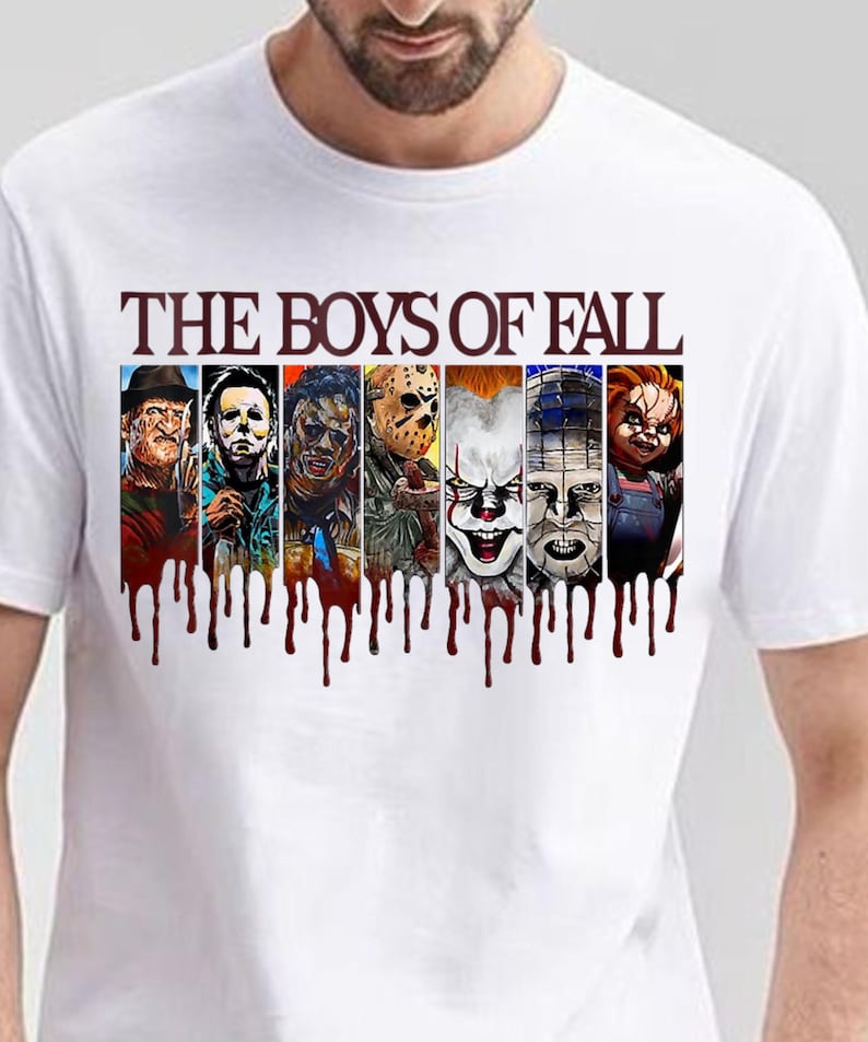May include: A white t-shirt featuring the text THE BOYS OF FALL in dark red letters above seven vertical panels depicting various horror movie characters. Below the panels, a dark red graphic effect resembles dripping blood across the chest.