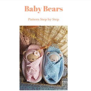 May include: Crocheted baby bear pattern. The image shows two crocheted baby bears, one wrapped in pink and the other in blue. The bears are nestled in crocheted cocoons. The text "Baby Bears" and "Pattern Step by Step" is at the top.