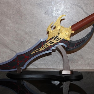 May include: A decorative fantasy dagger with a black and red blade, gold hilt, and brown handle. The blade has a unique curved design and is displayed on a black stand. The dagger is a collectible item.