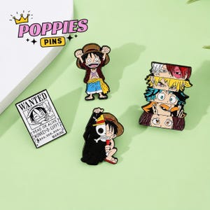 Puede incluir: Un conjunto de cuatro pines de esmalte con personajes de anime. Un pin es un cartel de búsqueda rectangular de Monkey D. Luffy. Dos pines muestran a Luffy en diferentes poses. Un pin vertical muestra una pila de cinco pares de ojos de anime.
