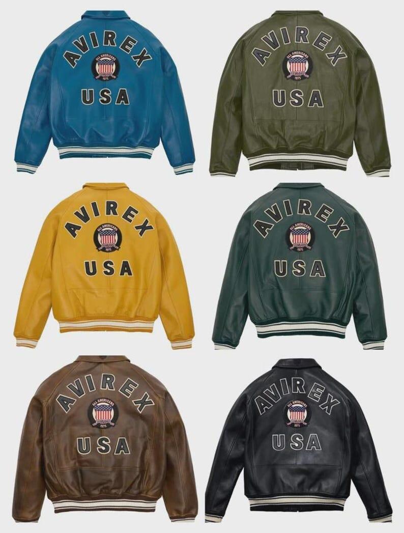 Puede incluir: Seis chaquetas bomber de cuero en varios colores: azul, verde, amarillo, verde oscuro, marr&oacute;n y negro. Cada chaqueta presenta el logotipo "AVIREX" y el texto "USA" en la espalda, con dobladillo y pu&ntilde;os a rayas. Las chaquetas son de estilo cl&aacute;sico.
