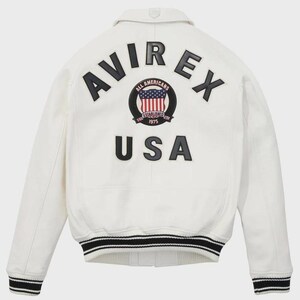 Puede incluir: Chaqueta bomber blanca con ribetes a rayas negras y blancas. La parte trasera presenta la palabra "AVIREX" sobre un parche circular con un dise&ntilde;o de bandera estadounidense y las palabras "ALL AMERICANS ESTABLISHED 1975". Debajo, la palabra "USA".