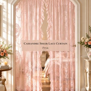 Può includere: Una coppia di tende in pizzo rosa chiaro semitrasparenti con un delicato motivo floreale e bordi arricciati, appese all'interno di una porta ad arco. Il testo "CASSANDRE SHEER LACE CURTAIN PINK" è centrato sulle tende in un riquadro.