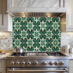May include: A decorative kitchen backsplash featuring a repeating geometric star pattern in shades of green, gold, and cream. The backsplash is installed above a stainless steel stove and adds a stylish accent to the kitchen.