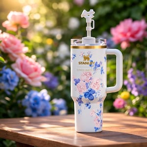 May include: White ceramic mug with a black handle, featuring the text "But First, Coffee" in black. The mug is displayed against a blurred backdrop, implying a comfortable environment.