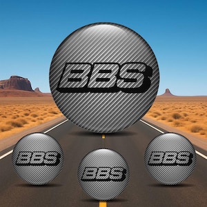 以下が含まれることがあります： BBSロゴのデザイン4点セット。メイン画像は、BBSのロゴが黒で表示された、光沢のあるカーボンファイバーテクスチャの大きな球体です。同じデザインの小さな球体が3つ、メイン球体の下に配置されています。背景には砂漠の風景と道路が描かれています。