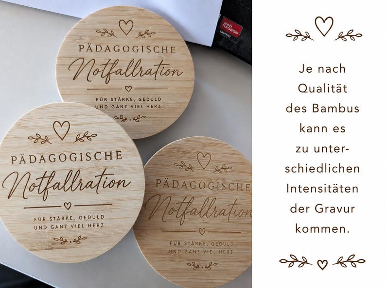 Op de afbeelding: Drie ronde bamboe onderzetters met een lasergegraveerde tekst die P&Auml;DAGOGISCHE Notfallration leest, gevolgd door F&Uuml;R ST&Auml;RKE, GEDULD UND GANZ VIEL HERZ. Elke onderzetter bevat decoratieve hart- en bladmotieven boven en onder de tekst.