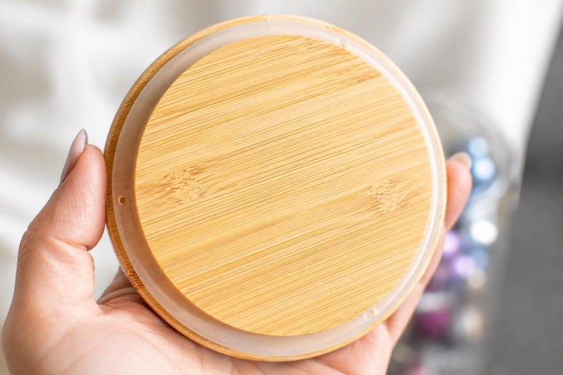 Op de afbeelding: Een cirkelvormig bamboe deksel met een natuurlijk houtnerfpatroon en een gladde, lichtbruine afwerking. Het deksel is voorzien van een doorschijnende, flexibele siliconen afdichtingsring aan de buitenrand voor een veilige afsluiting.