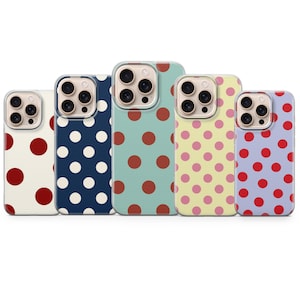 May include: Five phone cases with colorful polka dot patterns. The cases feature a variety of colors, including cream, navy blue, teal, yellow, and lavender. Each case has a different color of polka dots, such as red, white, and pink.