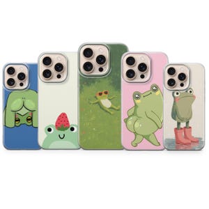 May include: Five phone cases with cartoon frog designs. The cases display different frog characters, such as a frog wearing sunglasses, a frog with a strawberry, and a frog in wellington boots. The cases are in shades of blue, green, and pink, offering a playful aesthetic.