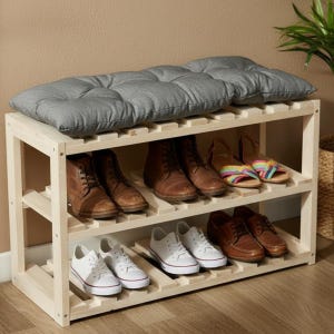 May include: A wooden shoe rack with three shelves, holding various shoes. The top shelf has a gray cushion. Shoes include brown boots, sandals, and white sneakers. The rack is made of light-colored wood.