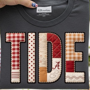 Peut inclure: T-shirt gris foncé avec le mot "TIDE" appliqué dans un motif patchwork. Les lettres présentent divers motifs, notamment du vichy rouge, des pois, des motifs floraux et des textures matelassées. La lettre "D" comprend la lettre "A" et la lettre "C" en écriture cursive.