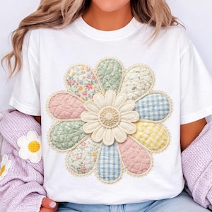 Könnte beinhalten: Weißes T-Shirt mit einem großen, gesteppten Blumendesign. Die Blume hat pastellfarbene Blütenblätter mit Blumen- und Vichy-Mustern und einen cremefarbenen Mittelteil. Das Design ist mit einem spitzenartigen Rand versehen.