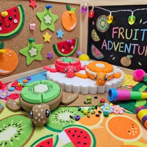 May include: A whimsical scene featuring fruit-themed decorations and toys. Felt watermelon and kiwi slices, star-shaped kiwi, and orange decorations adorn a corkboard. The phrase "FRUIT ADVENTURE" is written on a chalkboard. Turtle toys are designed to look like fruit.
