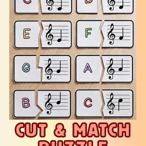 May include: A musical puzzle with white rectangular pieces featuring letters and musical notes. The puzzle pieces are designed to be cut and matched. The text "CUT & MATCH PUZZLE" is displayed in red letters at the bottom.