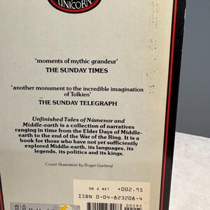 May include: The back cover of a book titled "Unfinished Tales of N&uacute;menor and Middle-earth." The cover features quotes from The Sunday Times and The Sunday Telegraph. The book is published by Unicorn and includes a barcode and ISBN.