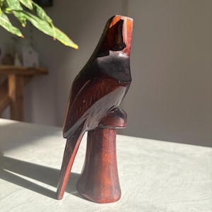 Hand-carved wooden bird of prey sculpture with incised feather detail