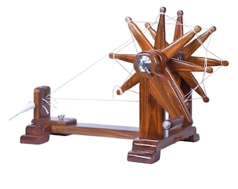 May include: A wooden spinning wheel with white thread wrapped around it. The wheel has eight spokes and is mounted on a wooden base.