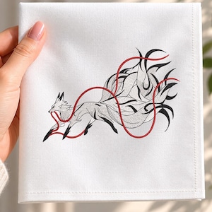 May include: A square white fabric napkin featuring an embroidered design of a multi-tailed fox in black thread. The fox is depicted in a dynamic pose, holding a thin, continuous red thread that winds around its body and tails.