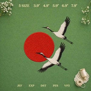 Puede incluir: Un diseño de bordado con dos grullas blancas de puntas negras volando cerca de un gran círculo rojo. El texto indica 5 SIZE 9,9 cm 12,4 cm 15,0 cm 17,5 cm 20,1 cm y JEF EXP DST PES VP3 sobre un fondo verde con detalles florales blancos.