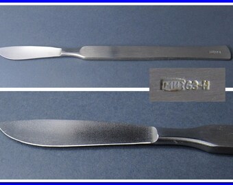 May include: A stainless steel surgical scalpel with a sharp blade and a handle with the inscription "MIR 63-H".