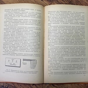 May include: An open book with text in Russian, featuring diagrams and technical illustrations. The pages are aged, with a visible spine and a wooden surface beneath.